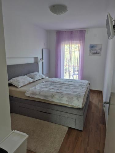 a bedroom with a bed and a window at Apartman Luka in Novigrad Istria