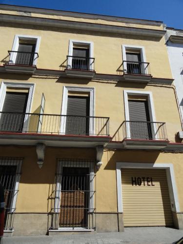 a yellow building with balconies and a hotel at Hotel El Coloso in Jerez de la Frontera