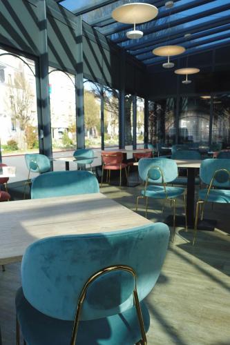 a group of chairs and tables in a building at Hôtel de la Gare - Restaurant Bistro Quai in La Roche-sur-Yon