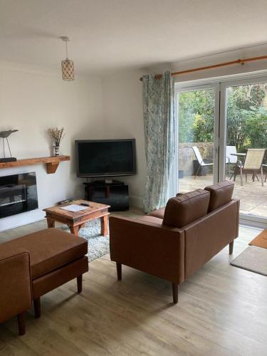 a living room with a couch and a television at Clarence House Shanklin in Shanklin
