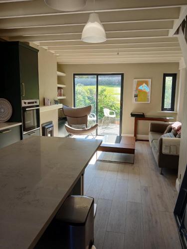 a kitchen and living room with a table and a couch at Thrush Cottage in Schull