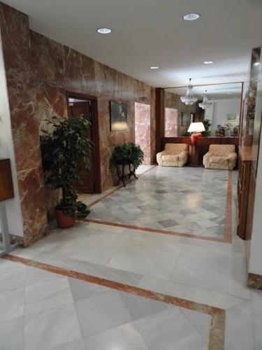 a large living room with a stone wall at Hotel El Coloso in Jerez de la Frontera