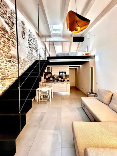 a living room with a couch and a staircase at Perla Loft in Seriate