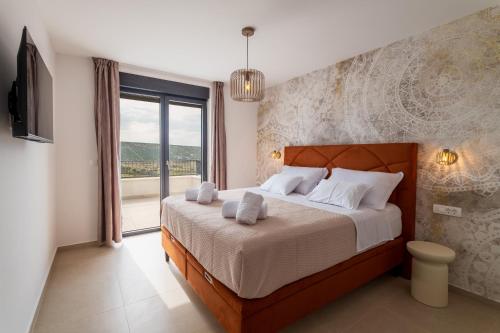 a bedroom with a large bed and a large window at Villa Carbonia in Kolan