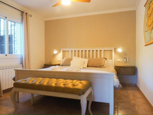 ein Schlafzimmer mit einem Bett und einer Bank darin in der Unterkunft Marimonta in Cómpeta