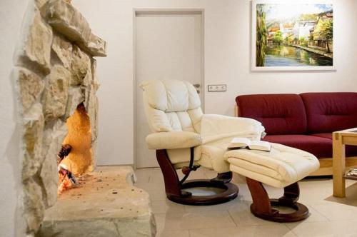 a living room with a chair and a fireplace at Haus "Am Mühlheimer Berg" in Mörnsheim