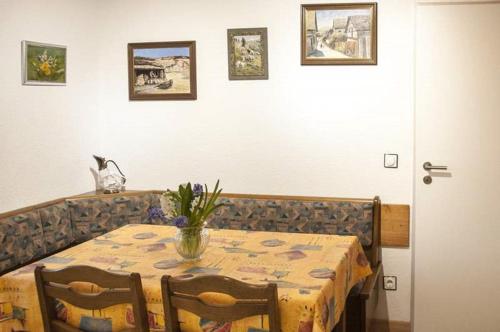 a dining room table with a vase of flowers on it at Haus "Am Mühlheimer Berg" in Mörnsheim