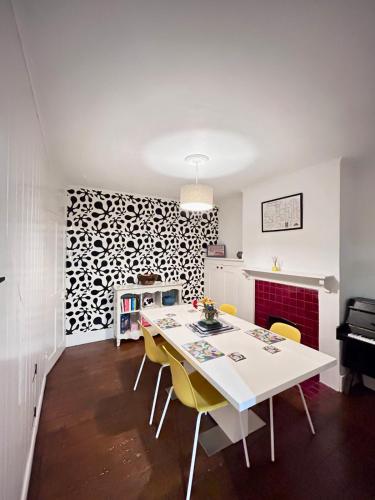 a dining room with a white table and yellow chairs at Charming 2 Bed Terrace in Central Caversham in Caversham