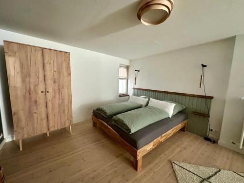 a bedroom with a bed and a wooden cabinet at Stadtwohnung Hygge Home in Neustadt in Holstein