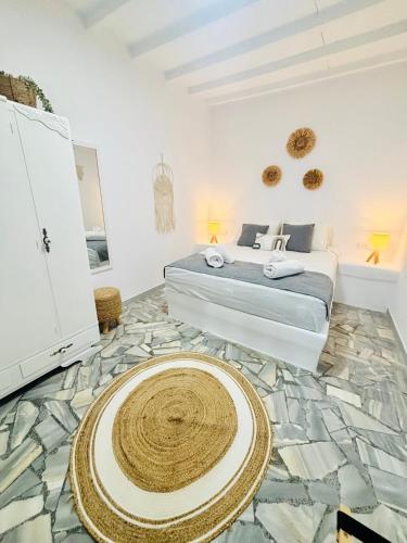 a bedroom with a bed and a large rug on the floor at Danae’s cycladic house in Kampos Paros