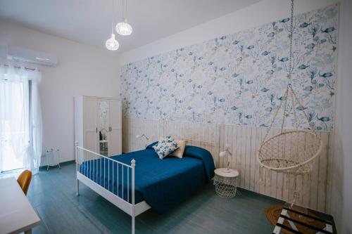 a bedroom with a blue bed and blue and white wallpaper at Residenza Delle Sirene in Gaeta