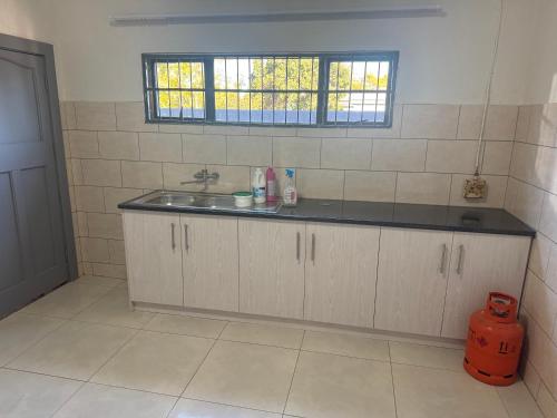 a kitchen with a sink and a window at Albam residency kuruman in Kuruman