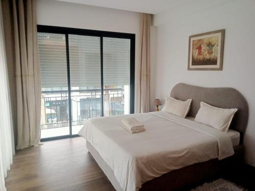 a bedroom with a large bed and a large window at Esmeralda in Douar el Hafey