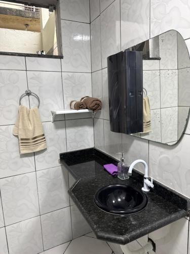 a bathroom with a black sink and a mirror at Casa Bragança suíte in Bragança