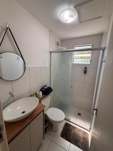 a bathroom with a toilet and a sink and a shower at Apartamento prático e aconchegante - 5 min do Centro in Catanduva