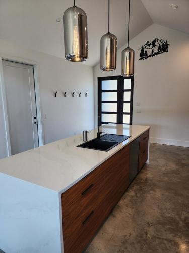 a kitchen with a counter and two pendant lights at Black Arrow Chalet in Courtenay