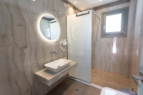 a bathroom with a sink and a mirror at ANAX APARTMENTS PARGA in Parga