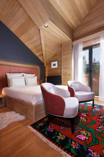 a bedroom with a bed and a chair and a rug at Swissôtel Resort Kolasin in Kolašin