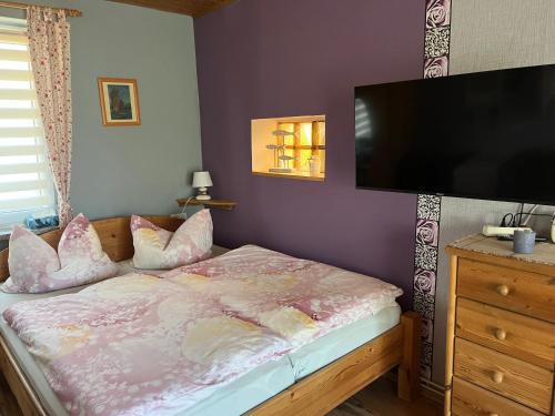 a bedroom with a bed and a flat screen tv at Apartment Rotdornblüte in Wustrow