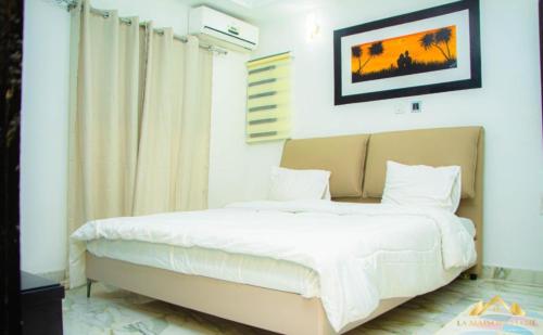 a bedroom with a large bed with white sheets at La MAISON SEONE PREMIUM in Abidjan