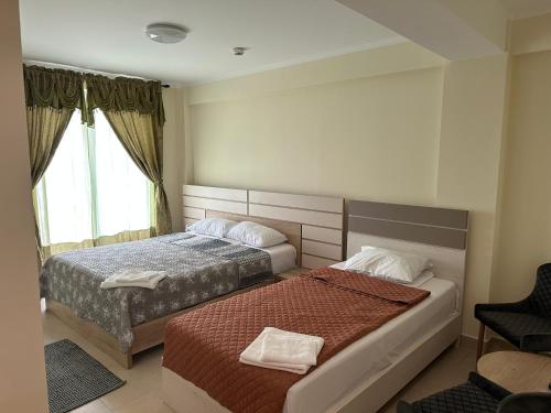 a hotel room with two beds and a window at Hotel Austin Ov in Ovidiu