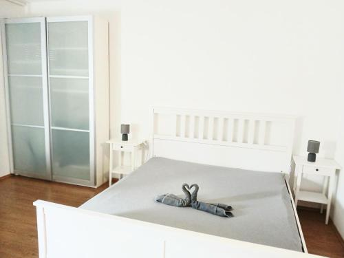 a white bedroom with a bed with a doll on it at Palatinus Lake in Dorog