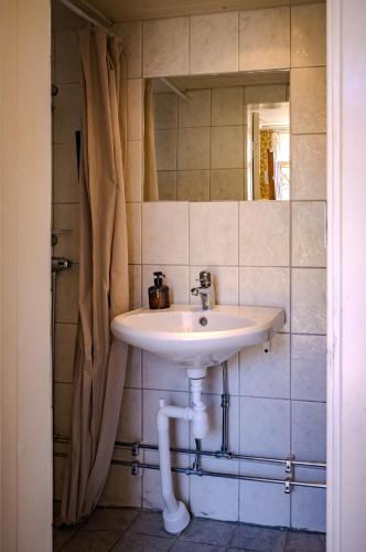 a bathroom with a sink and a mirror at Remarkable Harbour View Cabin. in Östhammar