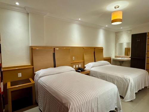 a hotel room with two beds in a room at Hotel Nilo in Acapulco