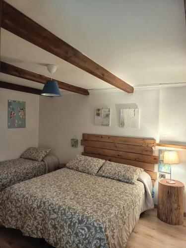 a bedroom with two beds and a wooden headboard at L'Armonica di Nonno Sandro in Corfinio