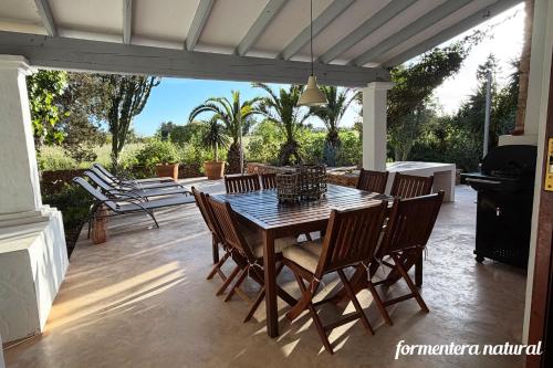 a table and chairs on a patio with a grill at Casa Lilu Playa Migjorn - Formentera Natural in Playa Migjorn