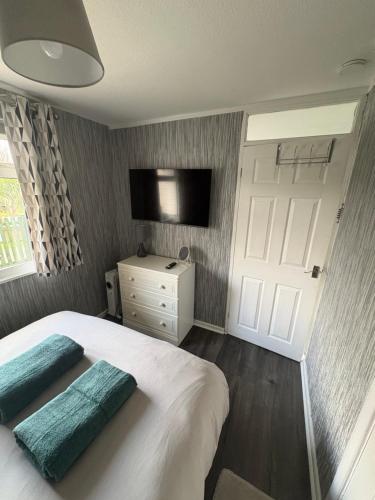 a bedroom with a bed with two pillows on it at Modern retreat in Caernarfon