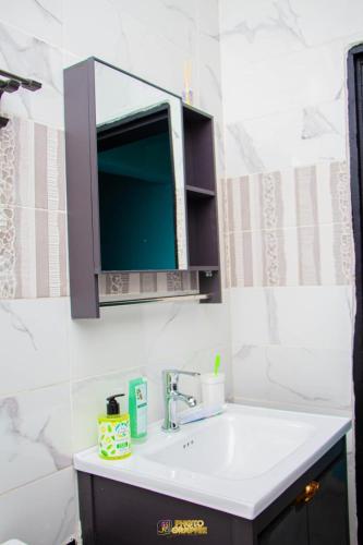 a bathroom with a sink and a mirror at La MAISON SEONE STANDARD in Abidjan