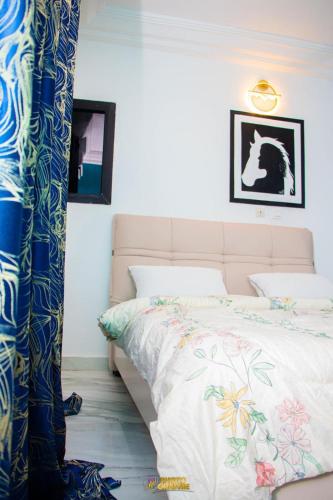 a bedroom with a bed with a white bedspread at La MAISON SEONE STANDARD in Abidjan