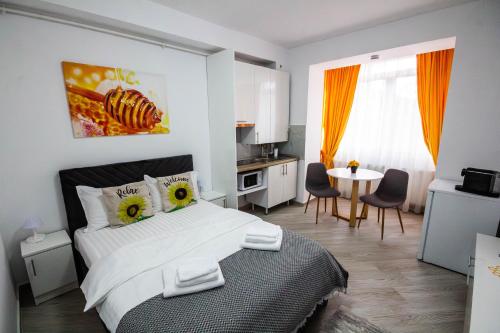 a bedroom with a bed and a table and a kitchen at Sun Studio Onești in Onești