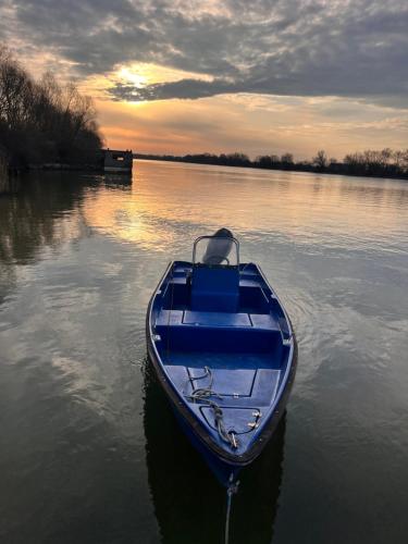 a blue boat in the water on a lake at Karina Maliuc Apartment in Maliuc