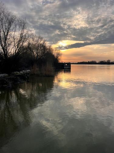 a view of a body of water with the sun setting at Karina Maliuc Apartment in Maliuc
