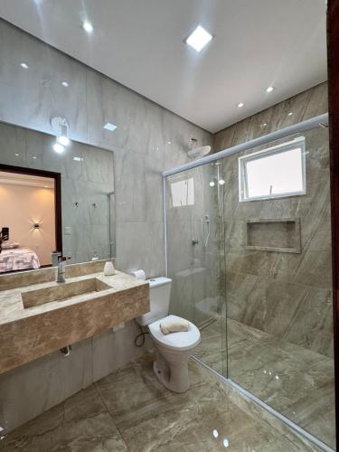 a bathroom with a toilet and a shower and a sink at Suítes Mazzioni in Socorro