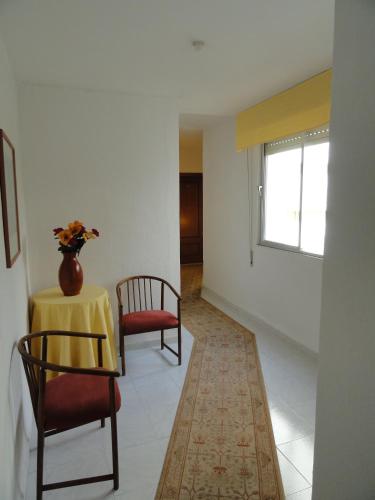 a room with two chairs and a table with a vase on it at Hotel El Coloso in Jerez de la Frontera