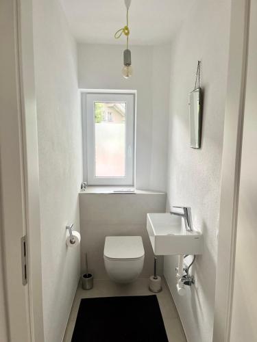 a white bathroom with a toilet and a sink at Ferienwohnung IMMI in Ruhpolding