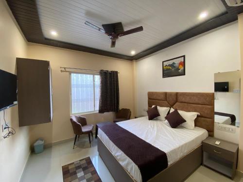 a bedroom with a bed and a ceiling fan at Rudravasa Inn in Varanasi