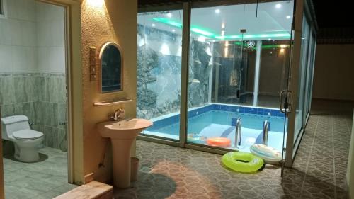 a bathroom with a tub with a sink and a toilet at شالهيات ريست 2 in Hail