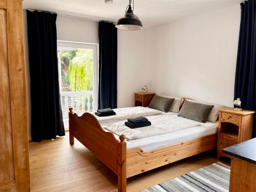 a bedroom with a wooden bed in front of a window at Ferienwohnung IMMI in Ruhpolding