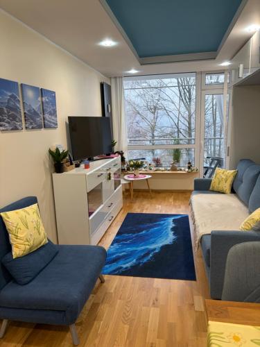 a living room with a couch and a tv at Apartament NIEBO Ustroń in Ustroń