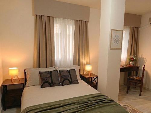 a bedroom with a bed with two lamps and a window at Forrent malaga in Málaga