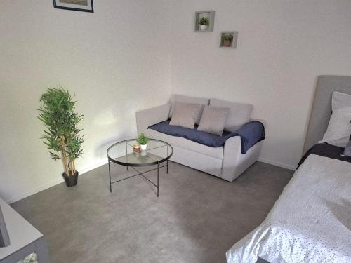a living room with a couch and a table at Studio moderne 33m2 Design cosy Wi Fi gratuit in Courcouronnes