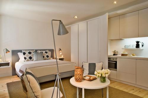 a bedroom with a bed and a table and a kitchen at Lisbon Five Stars Apartments Combro 77 in Lisbon
