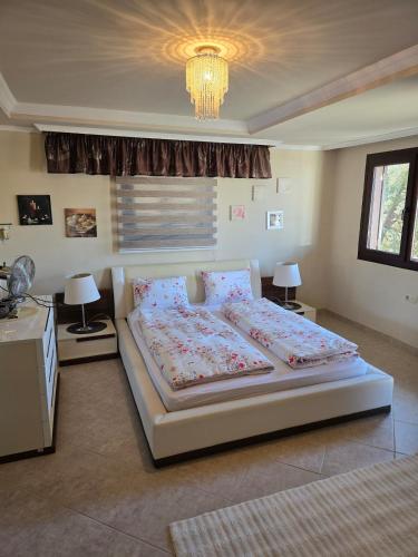 a bedroom with a bed and two lamps and a chandelier at Side Beach Villarında Dubleks Daire in Side