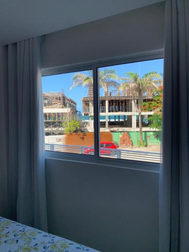 a bedroom window with a view of a city at Solar Porto Rico in Porto De Galinhas