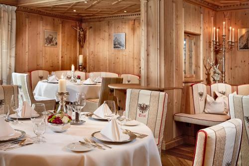 a restaurant with white tables and chairs and wooden walls at Relais&Châteaux Spa-Hotel Jagdhof in Neustift im Stubaital