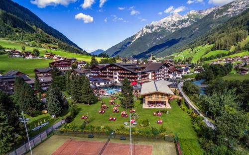a resort in the mountains with people sitting on a lawn at Relais&Châteaux Spa-Hotel Jagdhof in Neustift im Stubaital